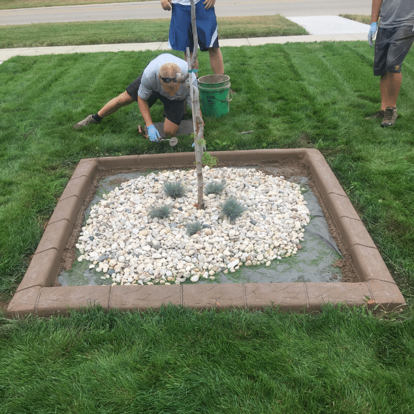 Concrete Curbing Installation Team Showcase Services team installing concrete curbing in residential yard